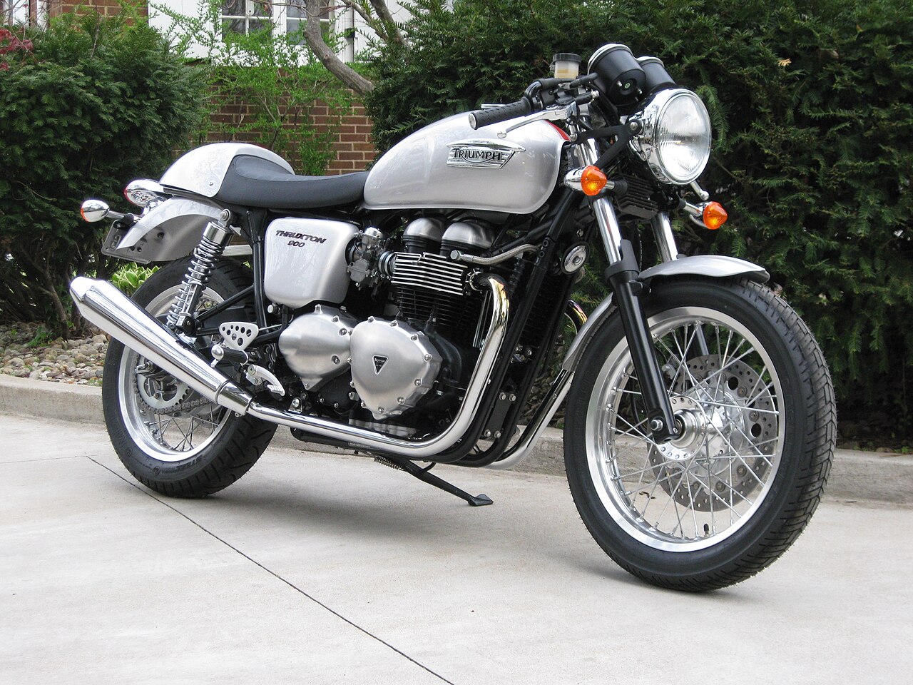 Silver 2008 Triumph Thruxton 900 with a solo-seat cowl, parked outdoors and viewed from the front right